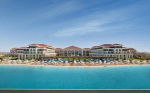 un resort sulla spiaggia con sedie e ombrelloni di Rixos Water World Aktau - Theme Park Free Access ad Aqtau