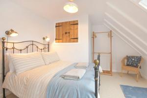 a bedroom with a bed and a chair at Seal Cottage in Burnmouth