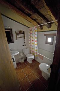 a bathroom with two toilets and a sink at Casa La Mestra in Herbeset