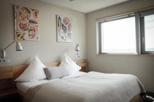 Schlafzimmer mit einem Bett mit weißer Bettwäsche und einem Fenster in der Unterkunft Gästehaus im Weingut am Stein in Würzburg