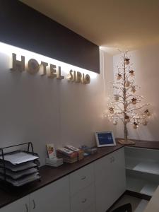 Zimmer mit Hotelschild und einem Schreibtisch mit Laptop in der Unterkunft Hotel Sirio in Reggio di Calabria