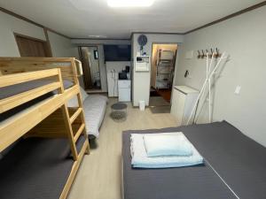 a small room with a bunk bed and a kitchen at Y's house in Seoul