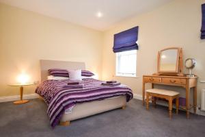 a bedroom with a bed and a dresser and a mirror at Churchside in Alnwick