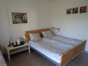 ein Schlafzimmer mit einem Bett und einem Tisch mit einem Nachttisch in der Unterkunft Het Herenhuis in Poroszló