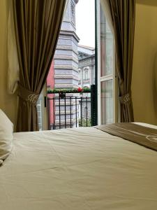 Schlafzimmer mit einem Bett und einem Fenster mit Aussicht in der Unterkunft MC Apartments in Neapel