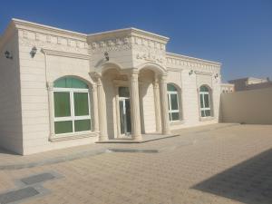 阿布達比的住宿－Cheerful 1BR Close to Abu Dhabi Airport and YAS Island，街道上一排有柱子的白色大建筑