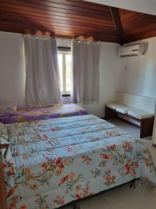 a bedroom with a bed with a colorful bedspread at Casa ferradura com piscina e hidromassagem in Búzios