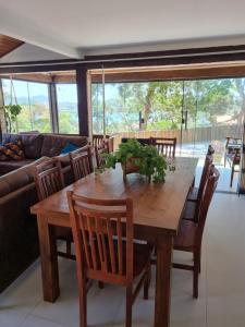 a dining room with a wooden table and chairs at Casa ferradura com piscina e hidromassagem in Búzios