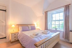 a bedroom with a large bed with towels on it at Dunlin Cottage in Bamburgh