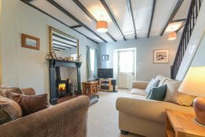 a living room with two couches and a fireplace at Hilltop Cottage in Wark