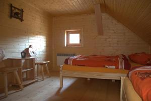 una habitación con 2 camas y una mesa en una cabaña en Horáreň pod Dobákom, en Lazisko