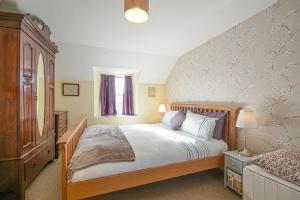 a bedroom with a large bed with a wooden headboard at Hilltop Cottage in Wark
