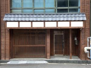 uma porta da frente de um edifício com um portão em Osaka Ukiyoe Ryokan em Osaka