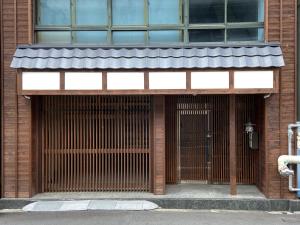 a front door of a building with a gate at Osaka Ukiyoe Ryokan in Osaka