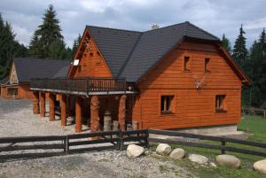 a large wooden cabin with a black roof at Horáreň pod Dobákom in Lazisko