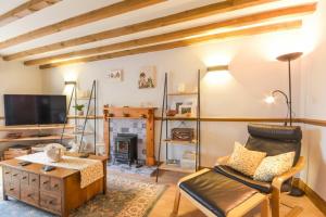 a living room with a couch and a fireplace at Mossyford Cottage in Alnwick