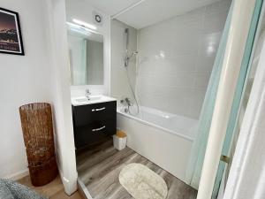 uma casa de banho com uma banheira branca, um lavatório e uma banheira. em Le Cliersou - Appartement bien situé à Clermont-Ferrand Fontgieve em Clermont-Ferrand