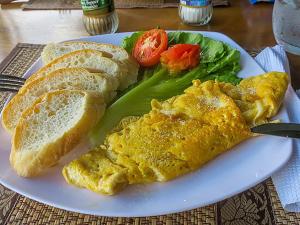 a plate of food with eggs and bread and vegetables at Side Walk Hotel in Siem Reap