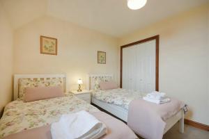 Un dormitorio con dos camas y una ventana. en Smithy Court, en Craster