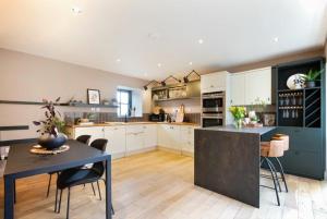 a large kitchen with a table and chairs in it at The Bolthole in Eglingham