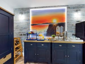 a kitchen with a painting on the wall at Driftwood Boutique Guest House in Rhosneigr