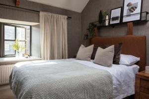 Un dormitorio con una gran cama blanca y una ventana en Lantern View, en Eglingham