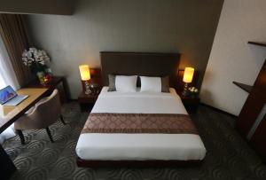 a hotel room with a large bed and a desk at Metrostar Hotel Kuala Lumpur in Kuala Lumpur