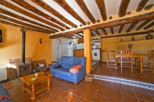 a living room with a blue couch and a table at Casa La Mestra in Herbeset
