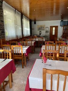 a dining room with tables and chairs with red tablecloths at Casa Samarra in Vall de Cardos
