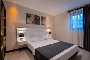 a bedroom with a bed and two tables and a window at ELUXİO SUİTE HOTEL in Antalya
