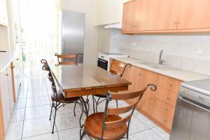 Il comprend une cuisine avec une table et des chaises en bois. dans l'établissement Aposperite Apartment, à Kalamata