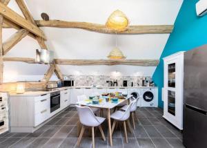 a kitchen with white cabinets and a table and chairs at La bergerie et Les Blés Dorés in Palleau