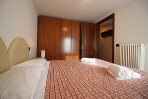 una camera da letto con un letto con due asciugamani bianchi di Residence Aquila - Bilo Mont Nery a Brusson