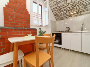 uma cozinha com uma parede de tijolos e uma mesa e cadeiras em Studio Joković em Vela Luka