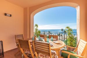 a dining room with a table and chairs and the ocean at BADIA DE ROSES 1 new apartment in Roses