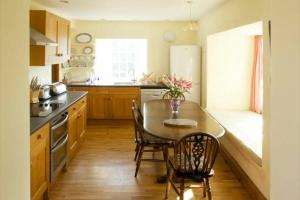 a kitchen with a table and chairs and a kitchen with a sink at Kirknowe in Jedburgh