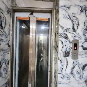 a elevator in a bathroom with a sign on the wall at HOTEL ROYAL AFGHAN in New Delhi