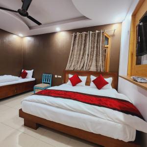 ein Schlafzimmer mit einem großen Bett mit roten Kissen in der Unterkunft HOTEL ROYAL AFGHAN in Neu-Delhi