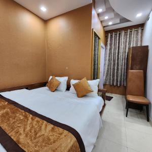 a bedroom with a large bed and a chair at HOTEL ROYAL AFGHAN in New Delhi