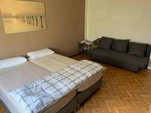 ein Schlafzimmer mit einem Bett und einer Couch in der Unterkunft LEA Apartments Leipzig West in Leipzig