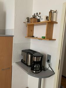 ein Küchenregal mit Kaffeemaschine darauf in der Unterkunft LEA Apartments Leipzig West in Leipzig
