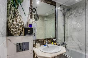 a bathroom with a sink and a shower at Prestige Deluxe Hotel Aquapark Club - All inclusive in Golden Sands