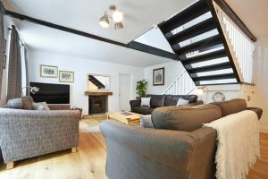 a living room with two couches and a fireplace at Old Stable Cottage in Alnmouth