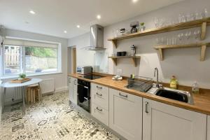 a kitchen with a sink and a counter top at Old Stable Cottage in Alnmouth