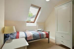 a small bedroom with a bed and a window at Old Stable Cottage in Alnmouth