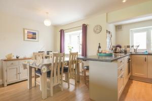 cocina y comedor con mesa y sillas en Schooner Court No1, en Alnmouth
