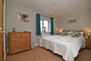 1 dormitorio con 1 cama, vestidor y ventana en Schooner Court No1, en Alnmouth