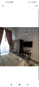 拿坡里的住宿－SUITE CASA FANZAGO，一间卧室配有一张床、一张桌子和一台电视。