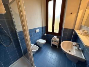 a blue bathroom with a toilet and a sink at Domus San Bernardino in Verona