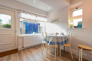a dining room with a table and chairs and a window at Ty y Mor in Seahouses